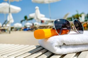Sunscreen, sunglasses, and towel
